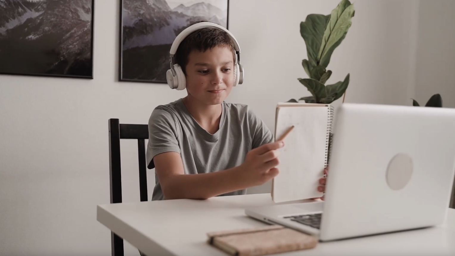 Desať ročný chlapec má individuálne online doučovanie z domu s jeho súkromnou lektorkou. Chlapec má bezdrôtové slúchadlá a sedí pred laptopom.